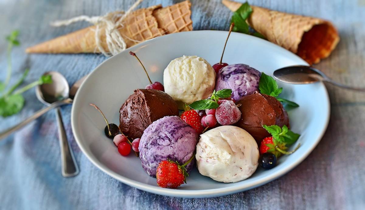 Assiette blanche avec des boules de glace variées et des fruits frais Assiette blanche avec des boules de glace variées et des fruits frais