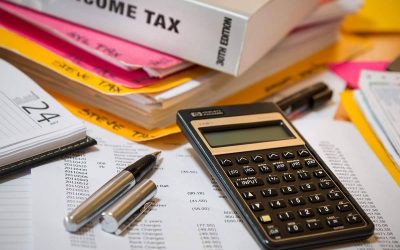 Calculatrice, stylos, documents et livres sur un bureau de travail
