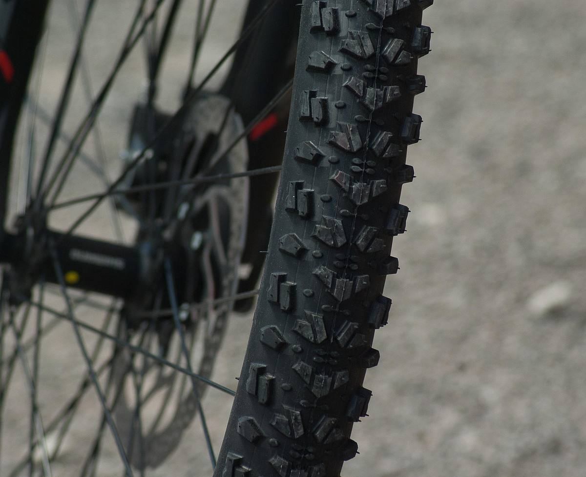 Gros plan du pneu crantele d'un vélo de montagne, prise de côté en extérieur