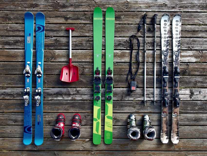 Skis, bottes et accessoires disposés sur une surface en bois Skis, bottes et accessoires disposés sur une surface en bois
